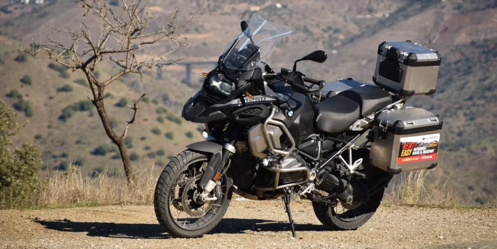 Motocykl BMW R 1250 GS Adventure z kuframi aluminiowymi na punkcie widokowym w hiszpańskich górach – Motorland.rent