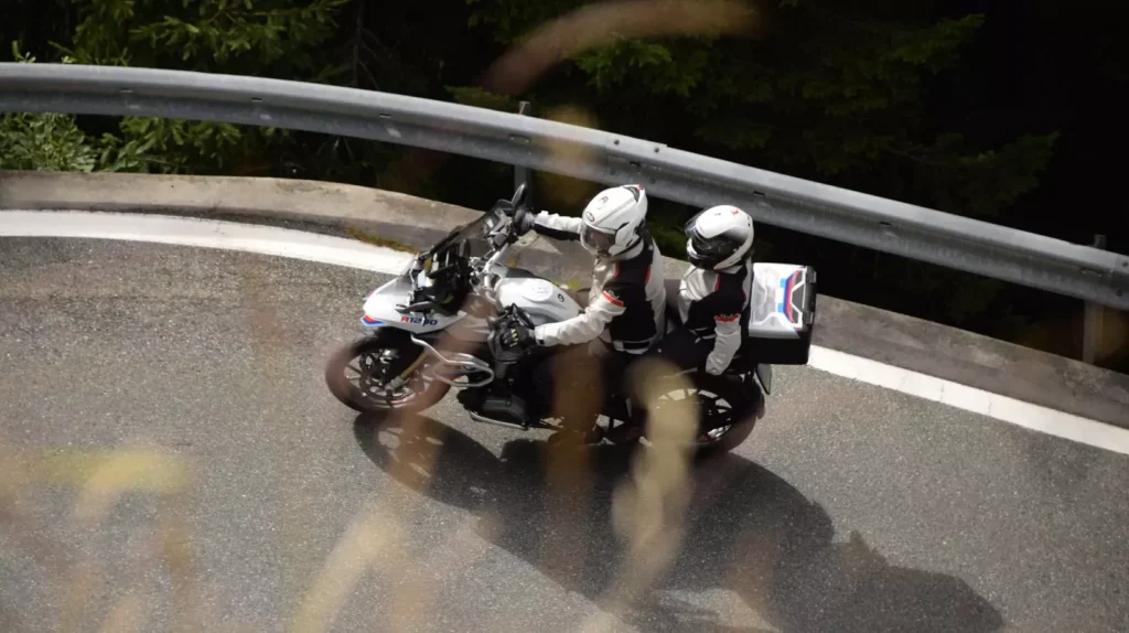 Para motocyklistów na motocyklu BMW R 1200 GS pokonująca ostry zakręt w górach – wypożyczalnia Motorland.rent