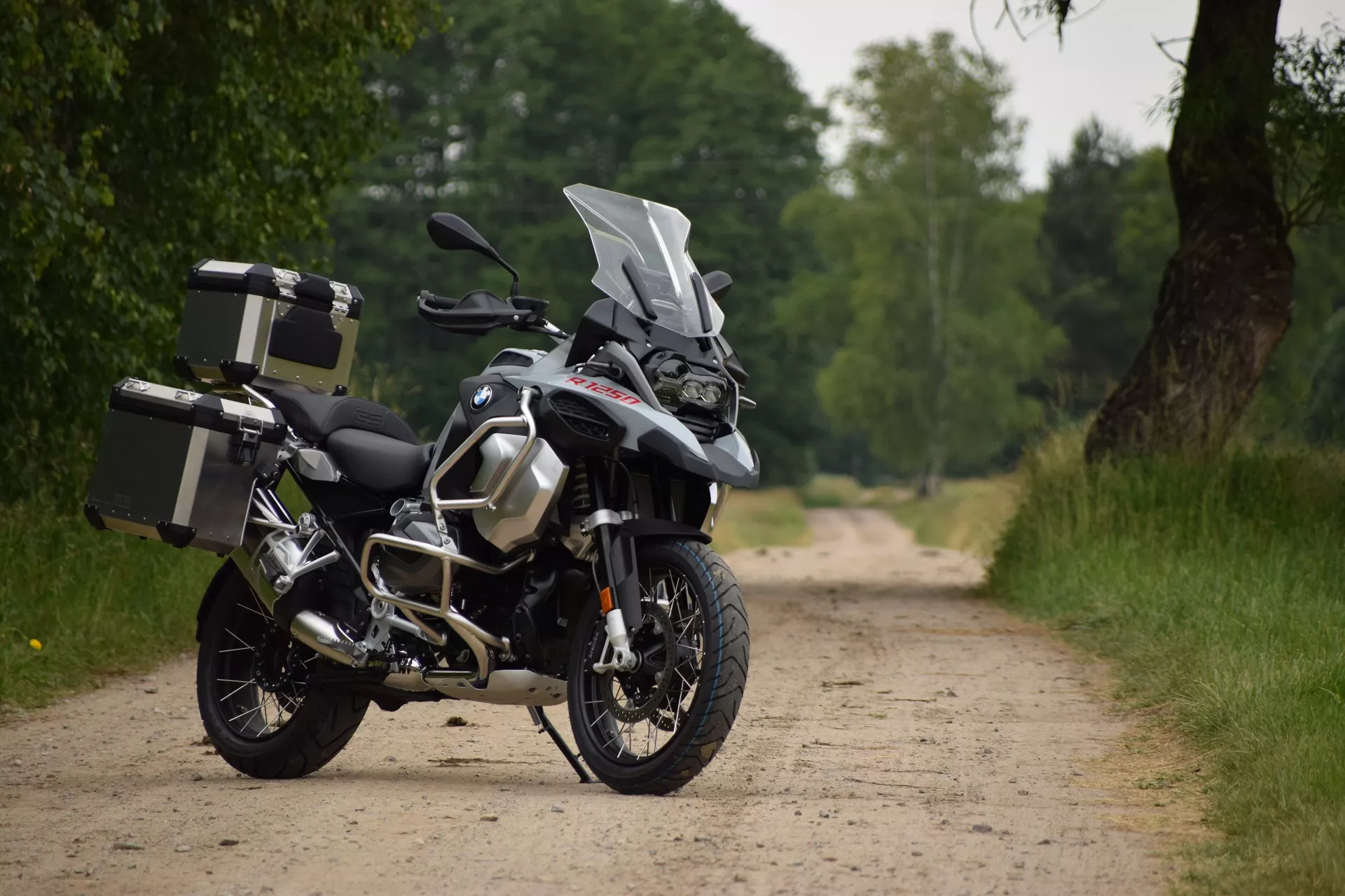 Motocykl BMW R 1250 GS Adventure z aluminiowymi kuframi na polnej drodze – wypożyczalnia motocykli Motorland.rent Polska
